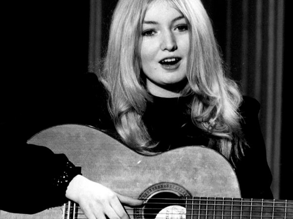 a black and white photo of mary hopkin with a guitar