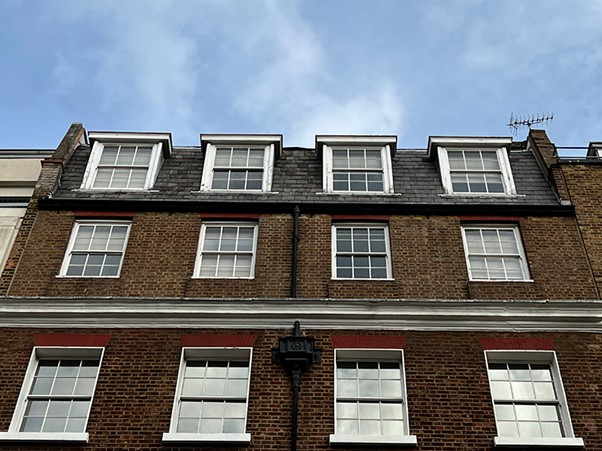 a photo taken from the street looking up at apple corps HQ, three saville row, london