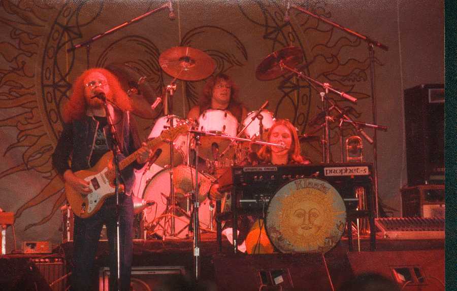 Klaatu performing a 1981 show. Dee Long on guitar, Terry Draper on drums, John Woloschuk on keyboard. Image © Vince Alexander