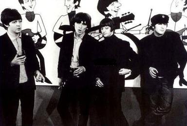 The Fab Four pose beside their newly created animated counterparts in London on 11 November 1964.